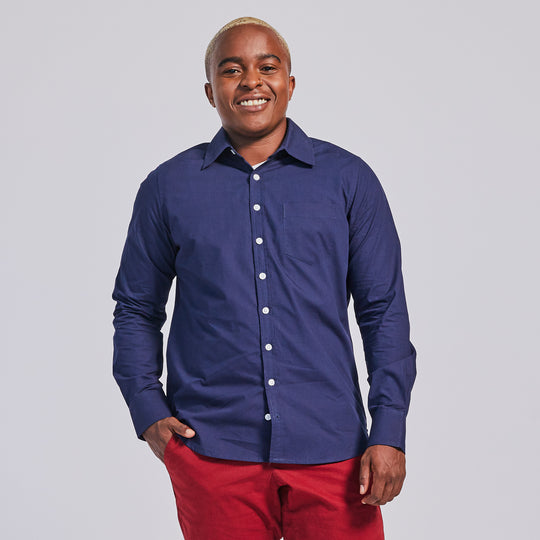 Masc presenting model in navy chambray point collar long sleeve shirt