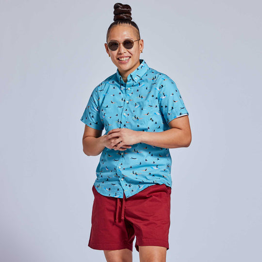 Non-binary model in red casual shorts and surfer print shirt