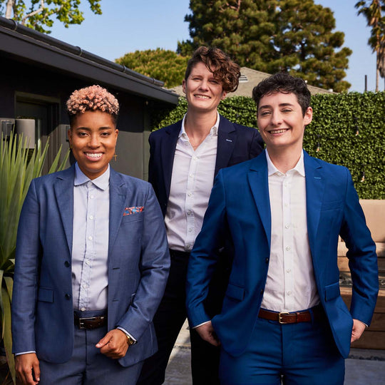 Three models in a swanky backyard showing off their blue suits in Navy, Slate, and Nautical