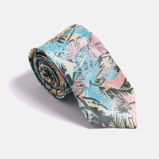 Skinny tie in a multicolored leaf print rolled upon itself on a white background
