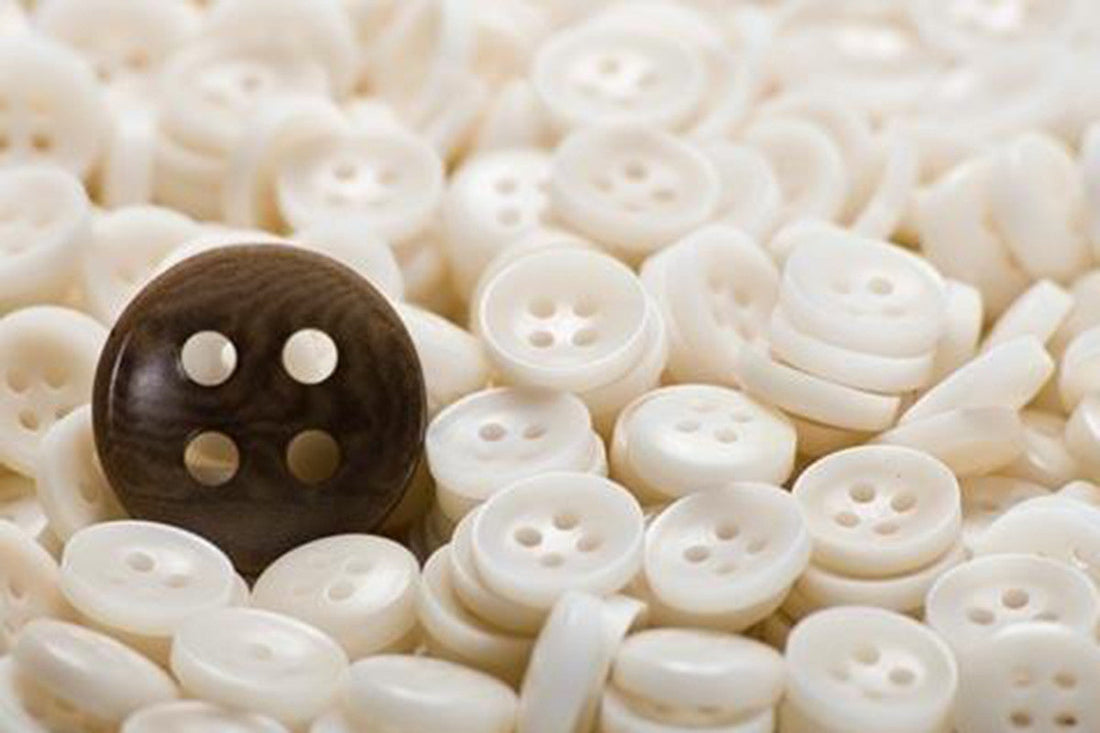 Many white buttons and one brown button.