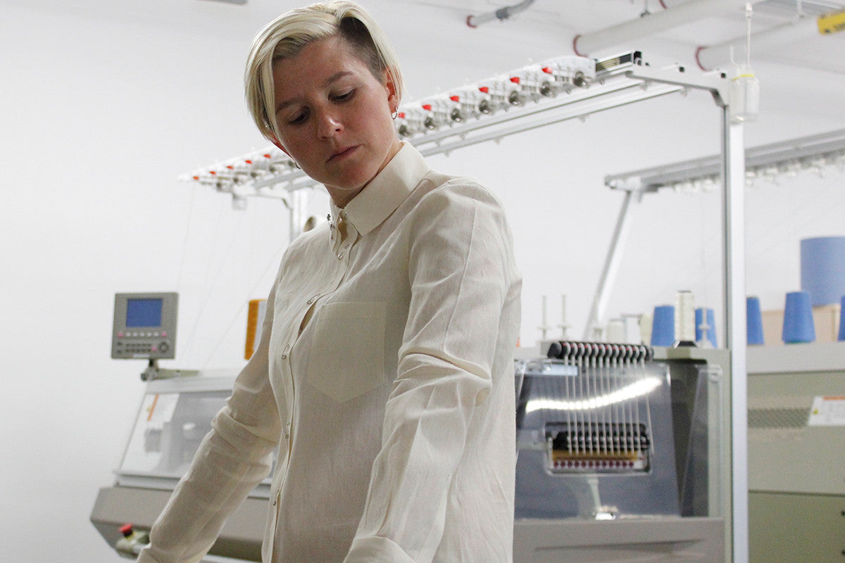 Kelly wearing and assessing the fit of a white dress shirt.