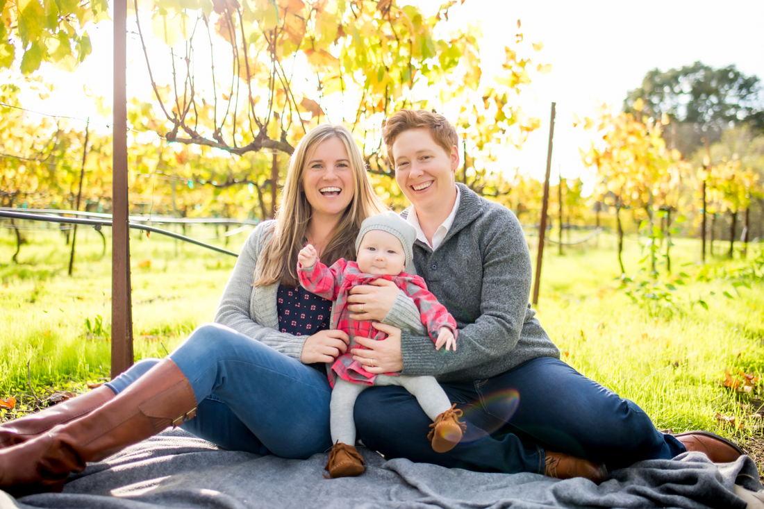 Family sitting on the floor in a park.