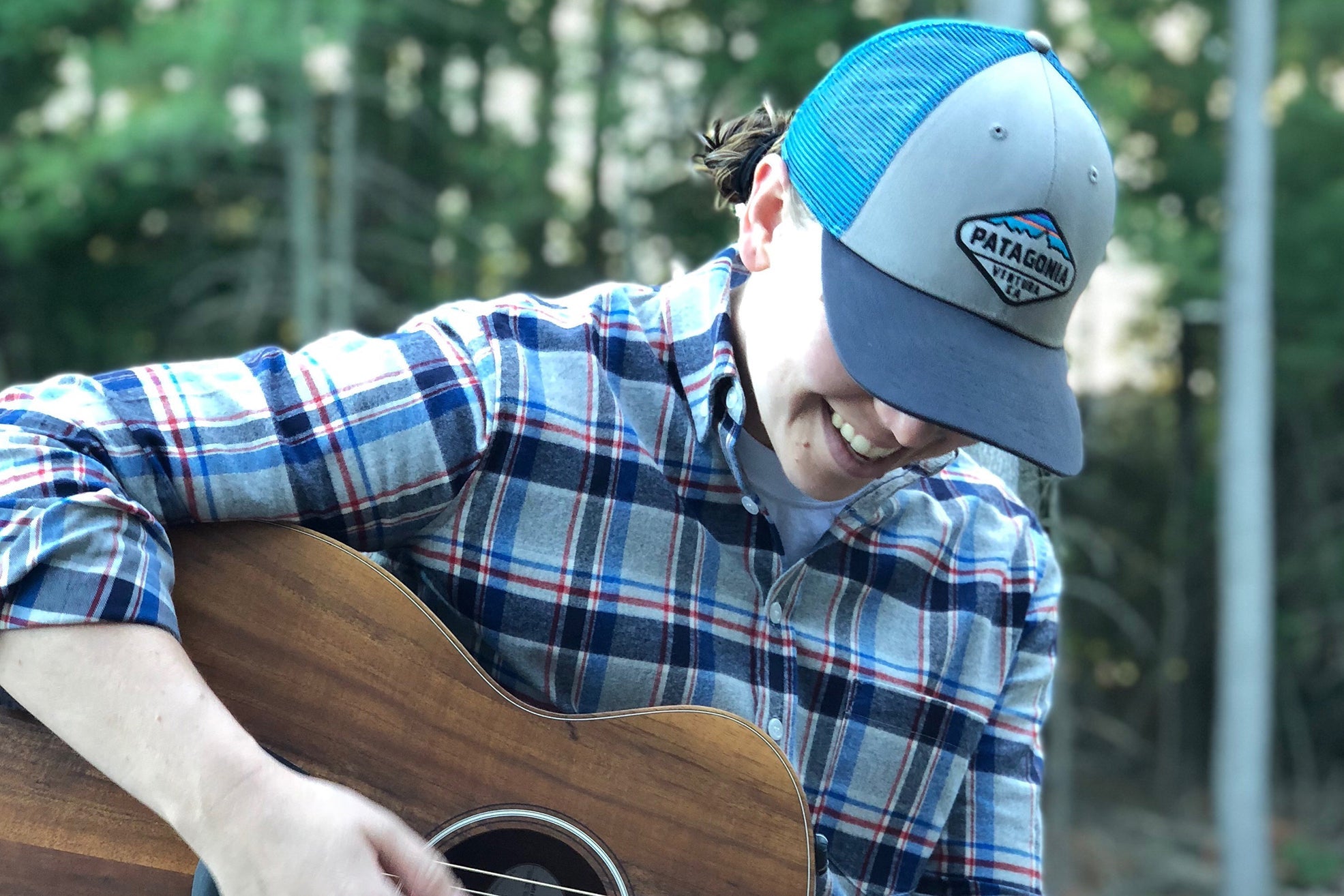 Whitney Borisenok playing acoustic guitar.