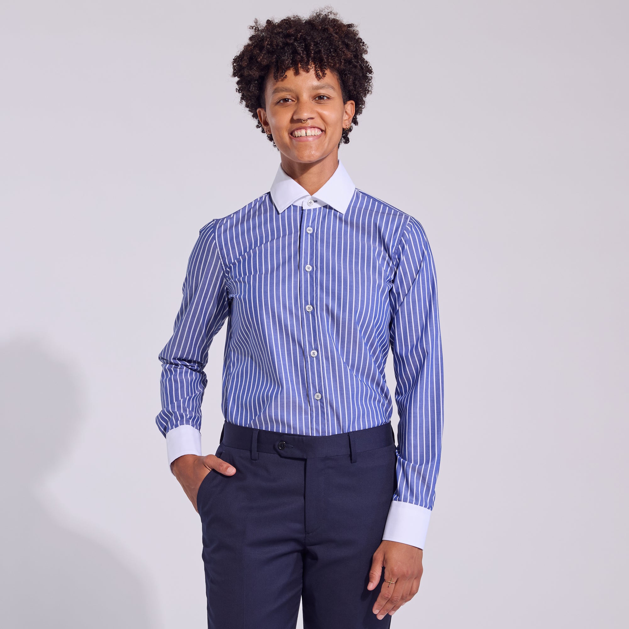 Androgynous model in dark blue pencil stripe dress shirt.