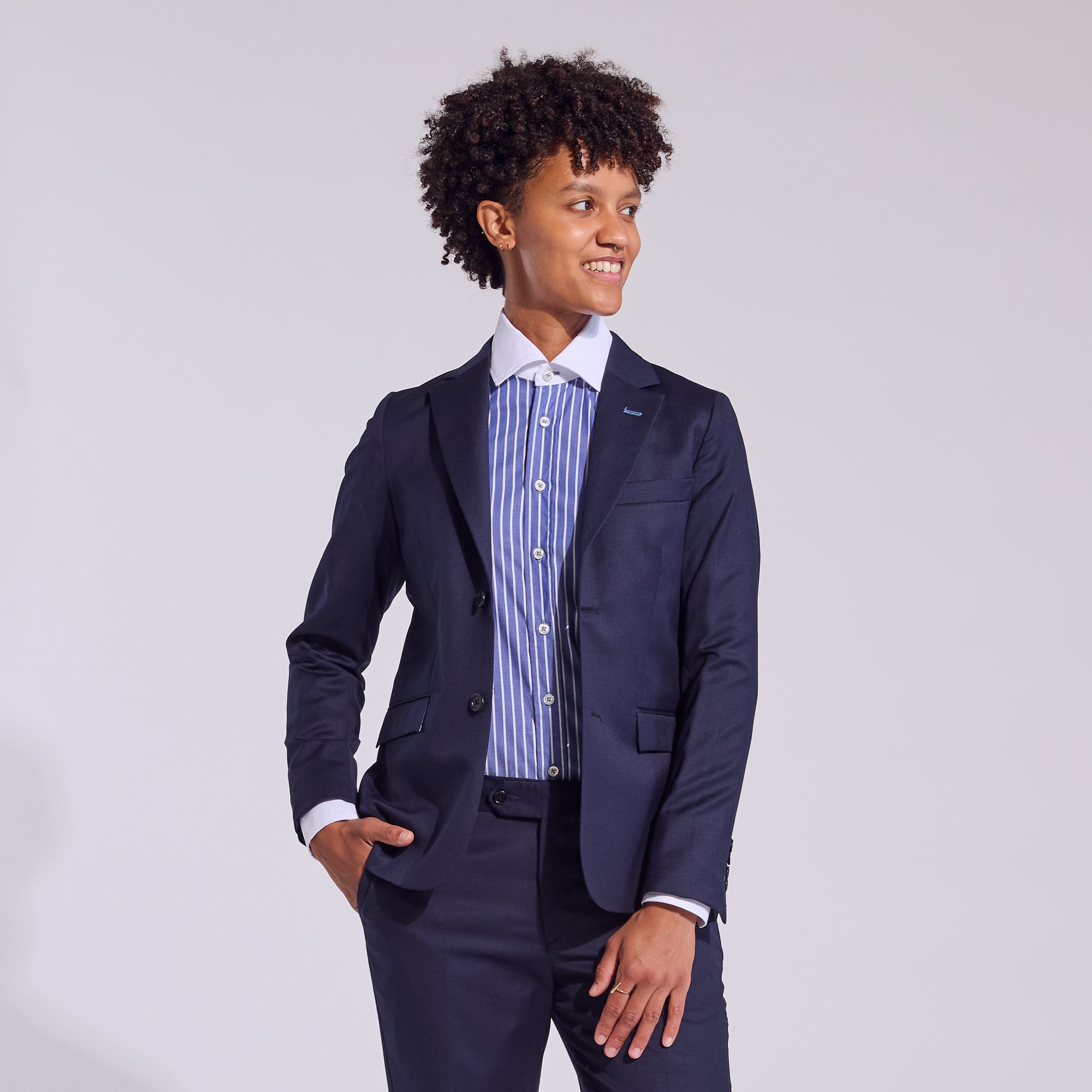 Model wearing dark blue banker shirt paired with blazer by Kirrn Finch.  Color: Blue Stripe Banker