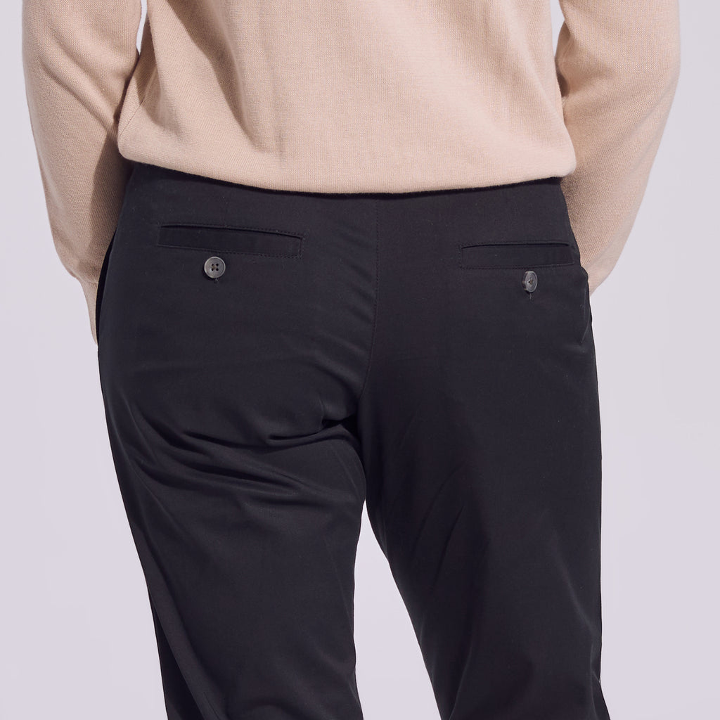 Black chinos with back pocket buttons.