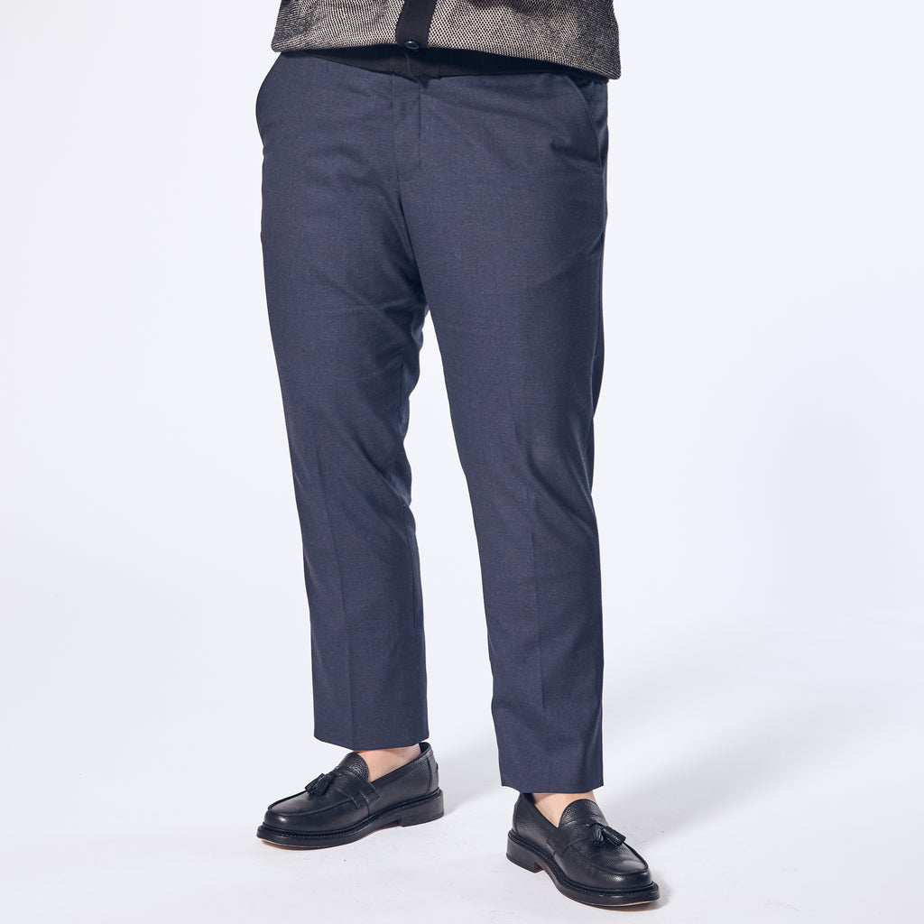 Model wearing The Scout Ink Blue Dress Pants made by Kirrin Finch on a white background