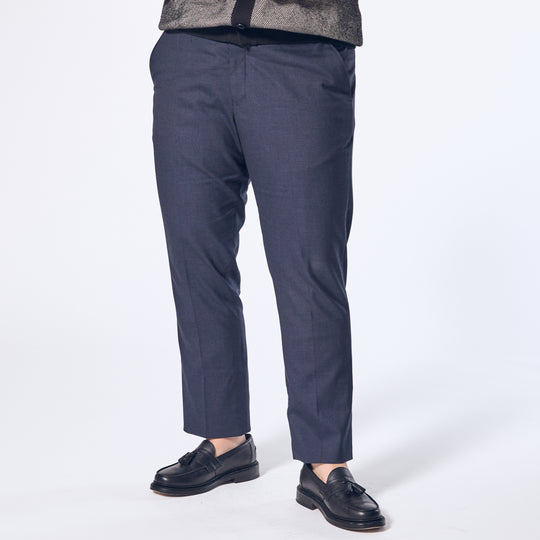 Model wearing The Scout Ink Blue Dress Pants made by Kirrin Finch on a white background