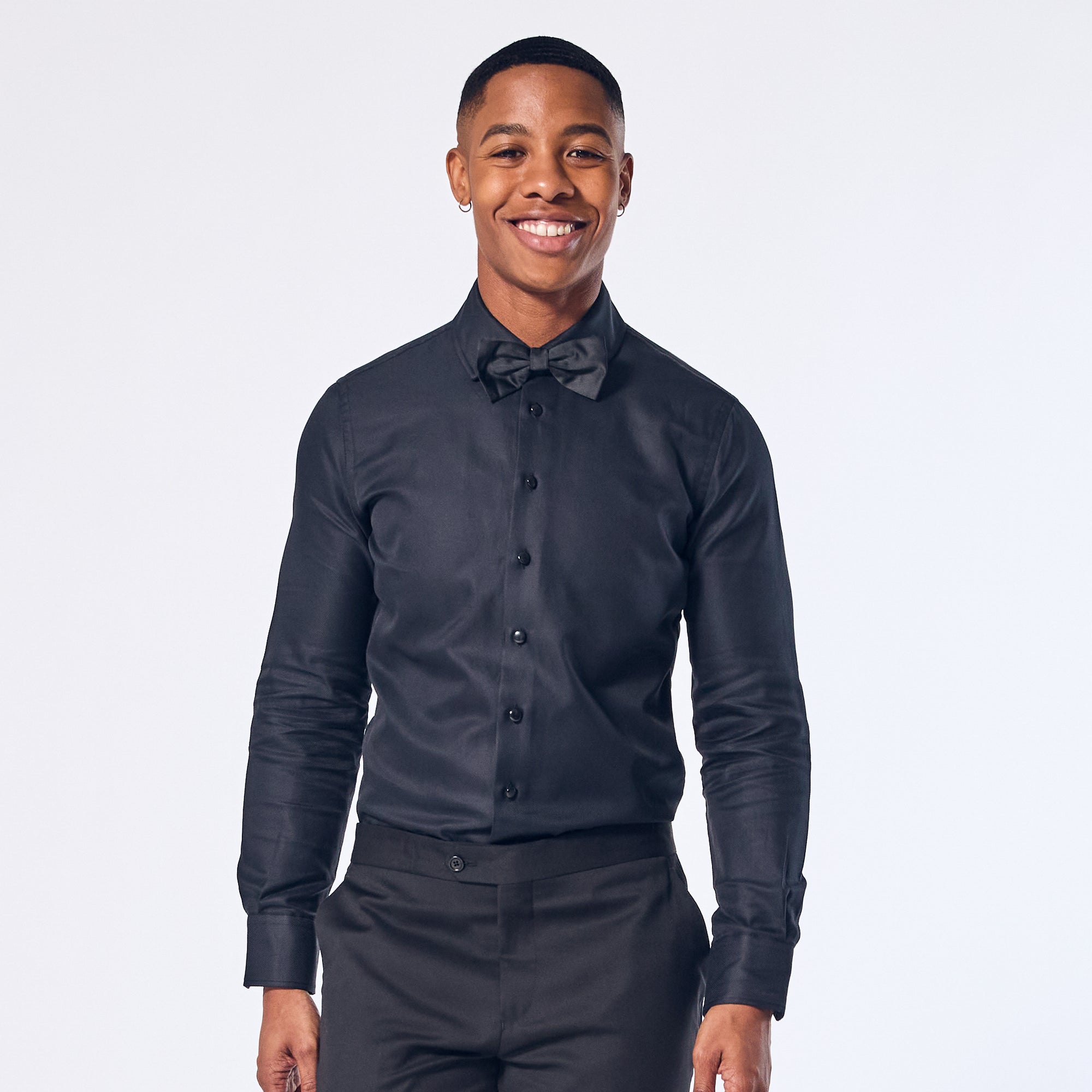 A person wearing a Jet Black Tuxedo Shirt with long sleeves, button-up front, and a collar.