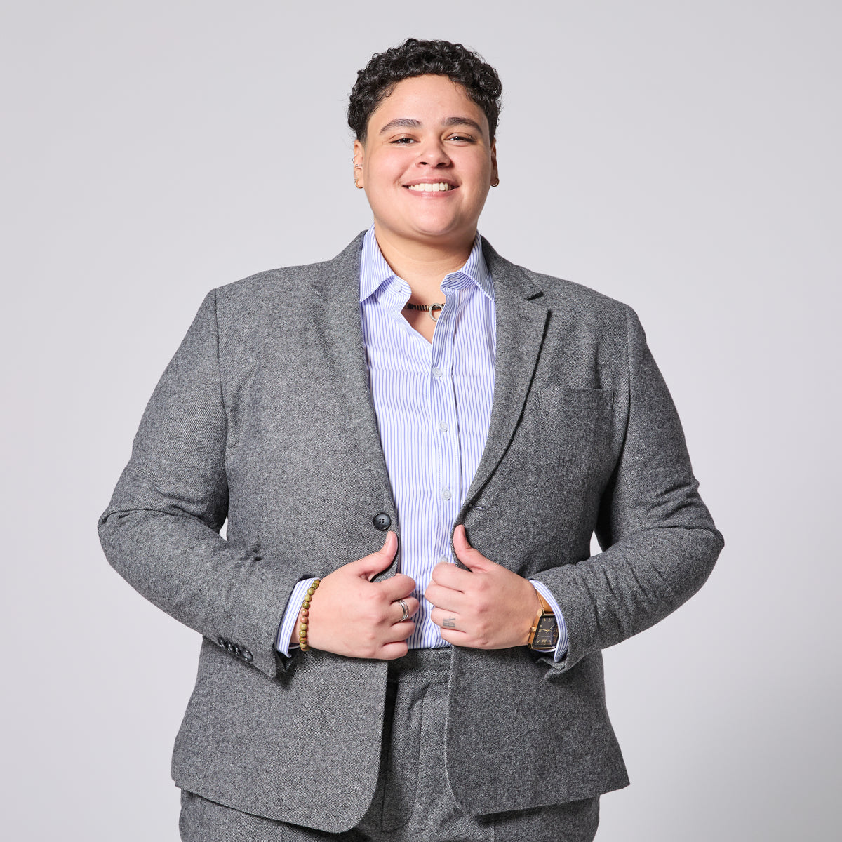 Person wearing Smokey Gray blazer over a light blue shirt on a plain background