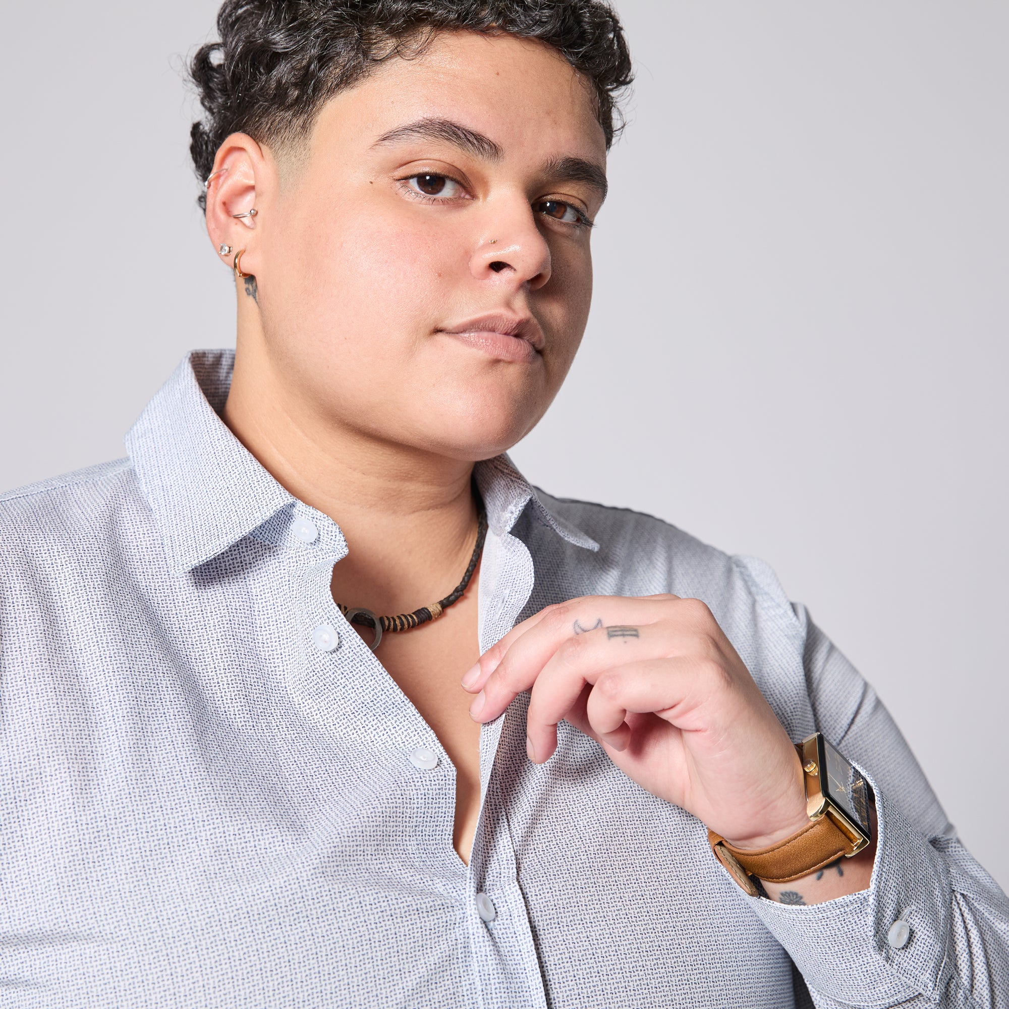 Person wearing a light gray shirt with a neutral background