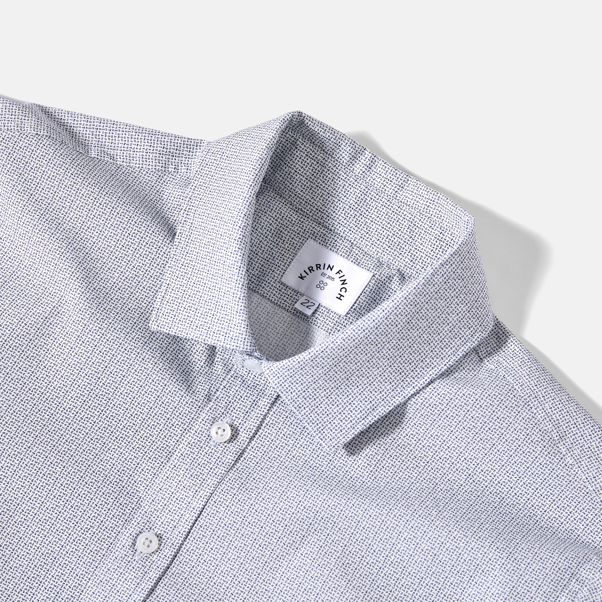 Close-up of a gray checkered shirt with a brand label on a white background. Color: Togo