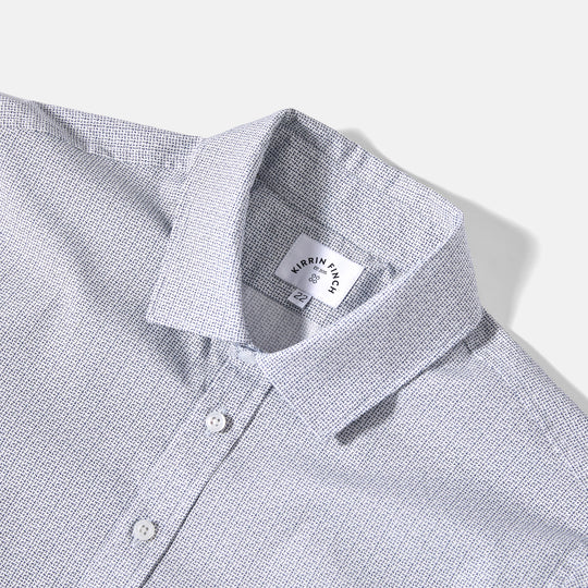 Close-up of a gray checkered shirt with a brand label on a white background