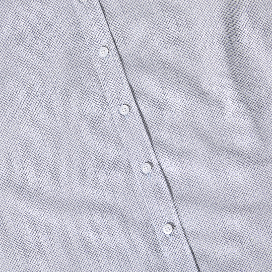 Close-up of a buttoned shirt with a subtle pattern