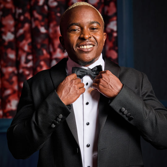 Masc model adjusting Kirrin Finch Bowtie on his Kirrin Finch Txuedo Shirt and Blazer