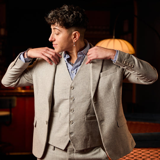 Model wearing The Finch Heather Gray Flannel Blazer made by Kirrin Finch in warm lighting.