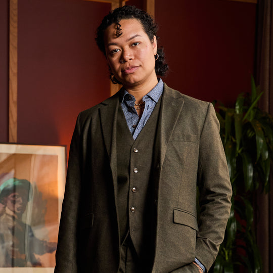 Model wearing The Finch Heather Olive Flannel Suit Blazer made by Kirrin Finch in indoor setting.