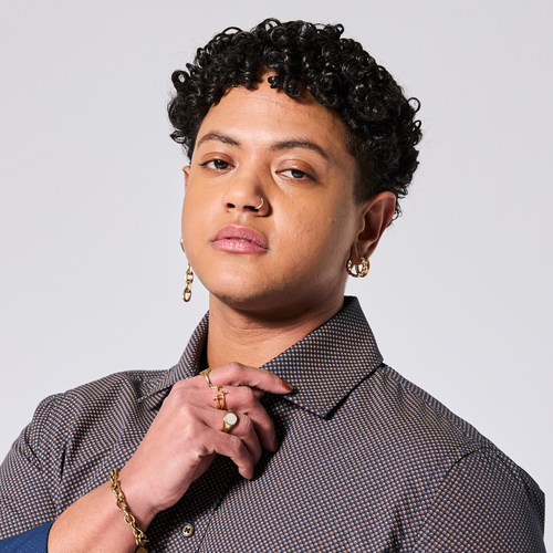 Androgynous model wearing a patterned shirt with jewelry on a plain background. Color: Moroccan Tile