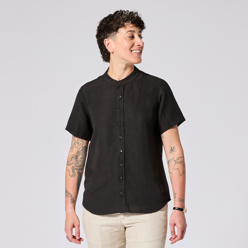 Model wearing a black short-sleeve shirt made for women, trans, masc and non-binary folk. Color: Black