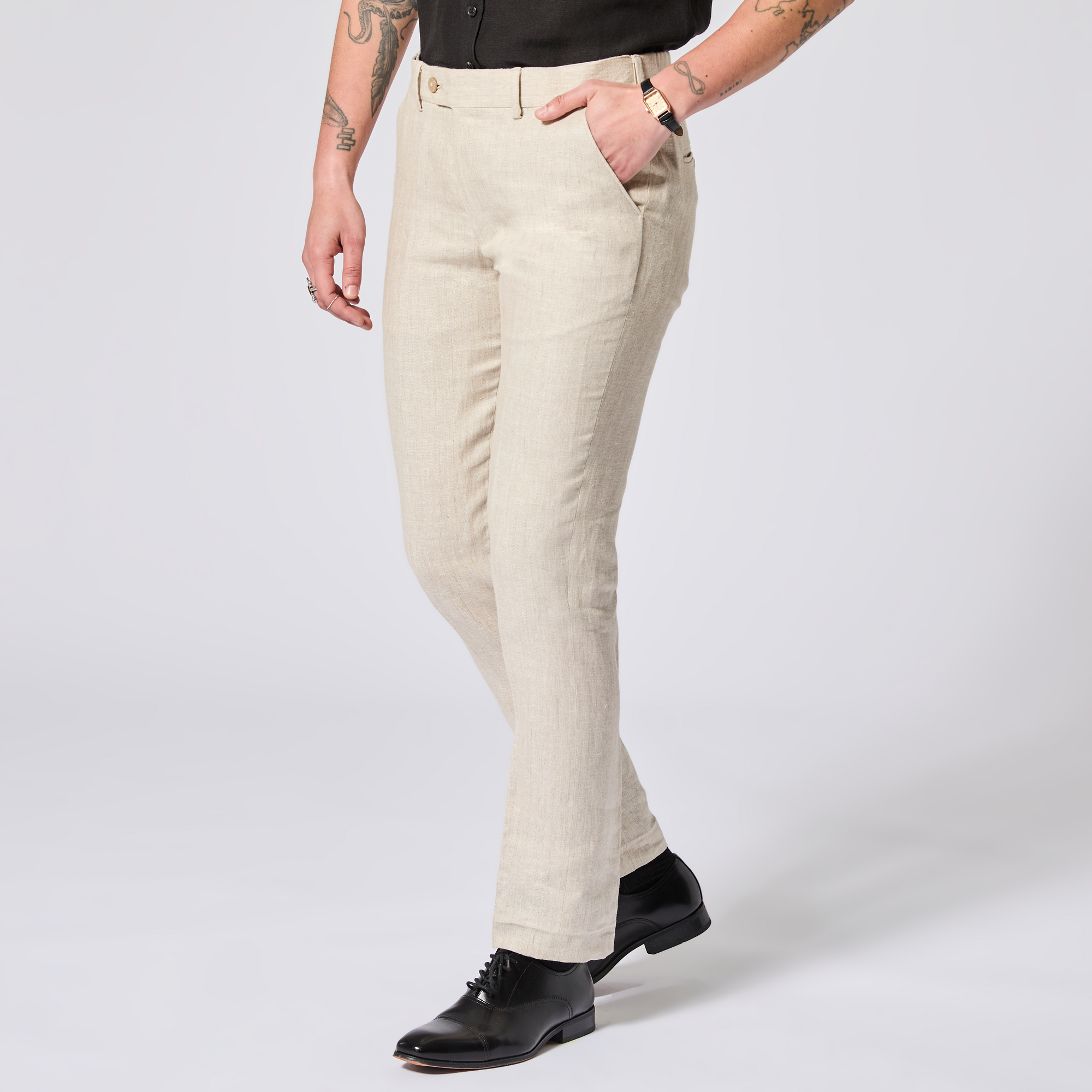 Person wearing beige pants and black shoes on a white background. Color: Khaki Herringbone