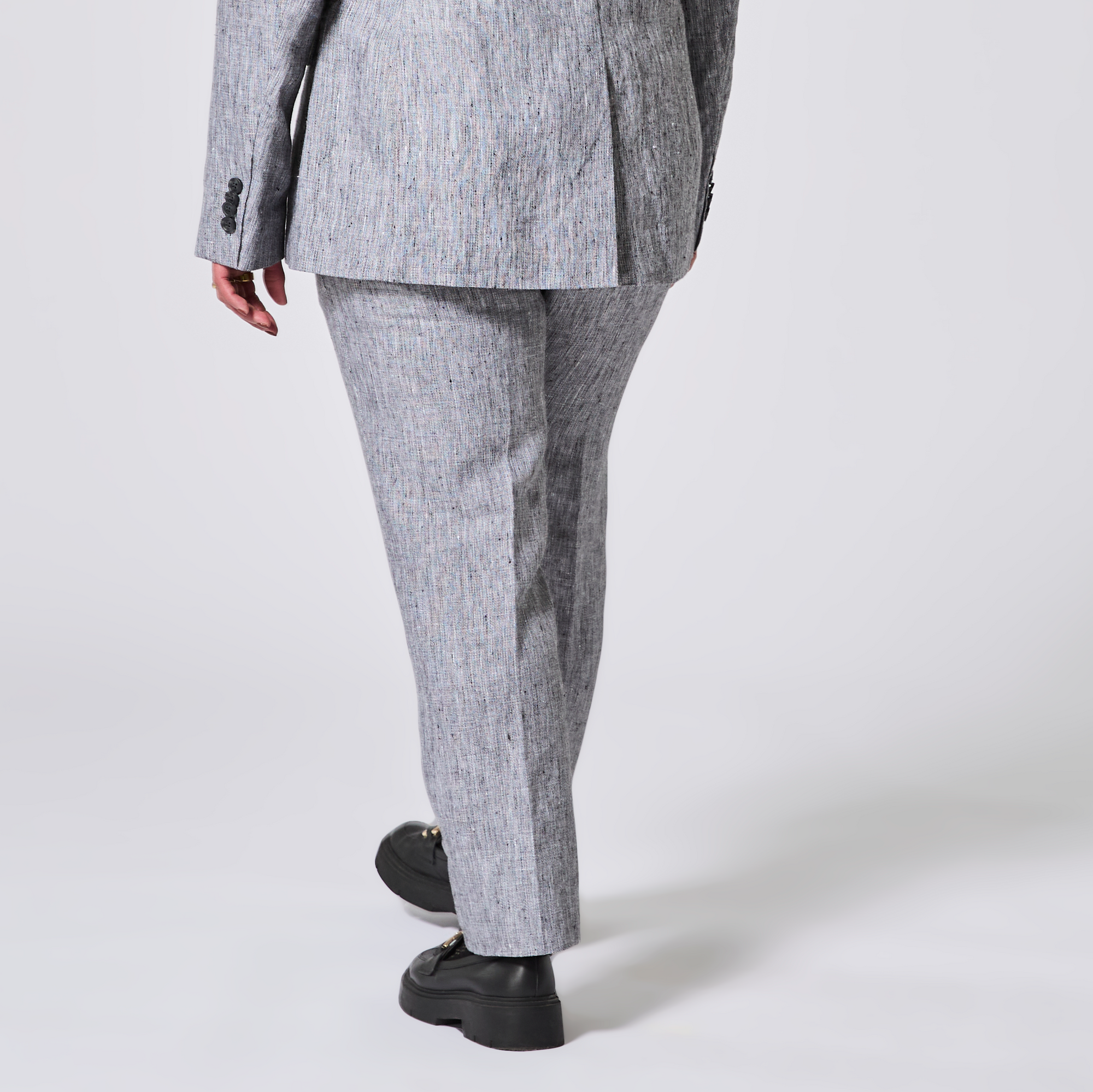 Person wearing a gray suit with black shoes on a white background. Color: Graphite