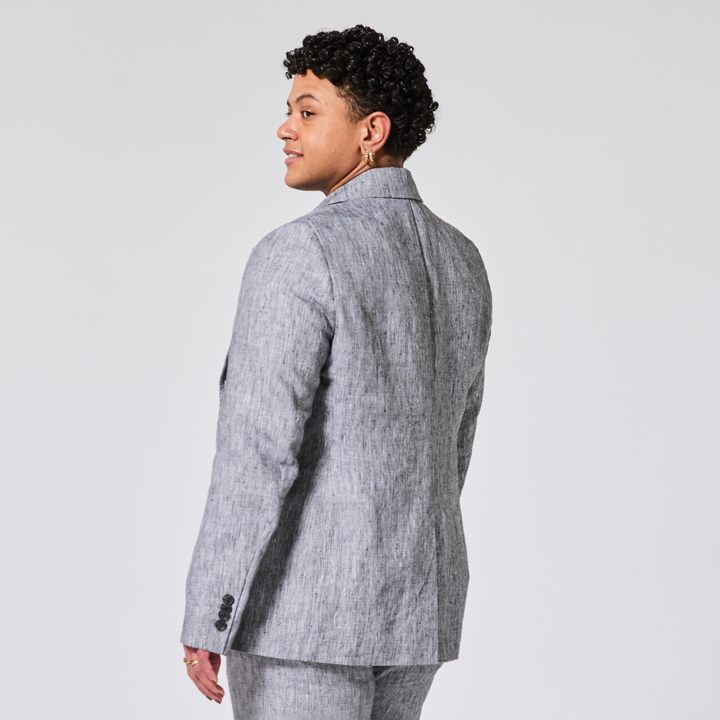 Person wearing a gray suit on a plain background. Color: Graphite