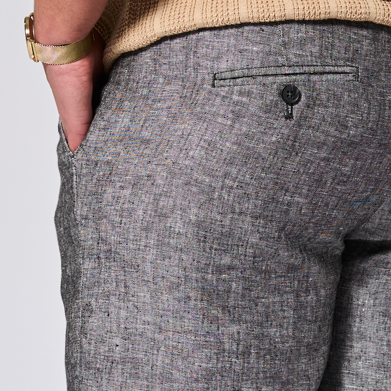 Gray textured pants with a button on a light gray background. Color: Ash Gray