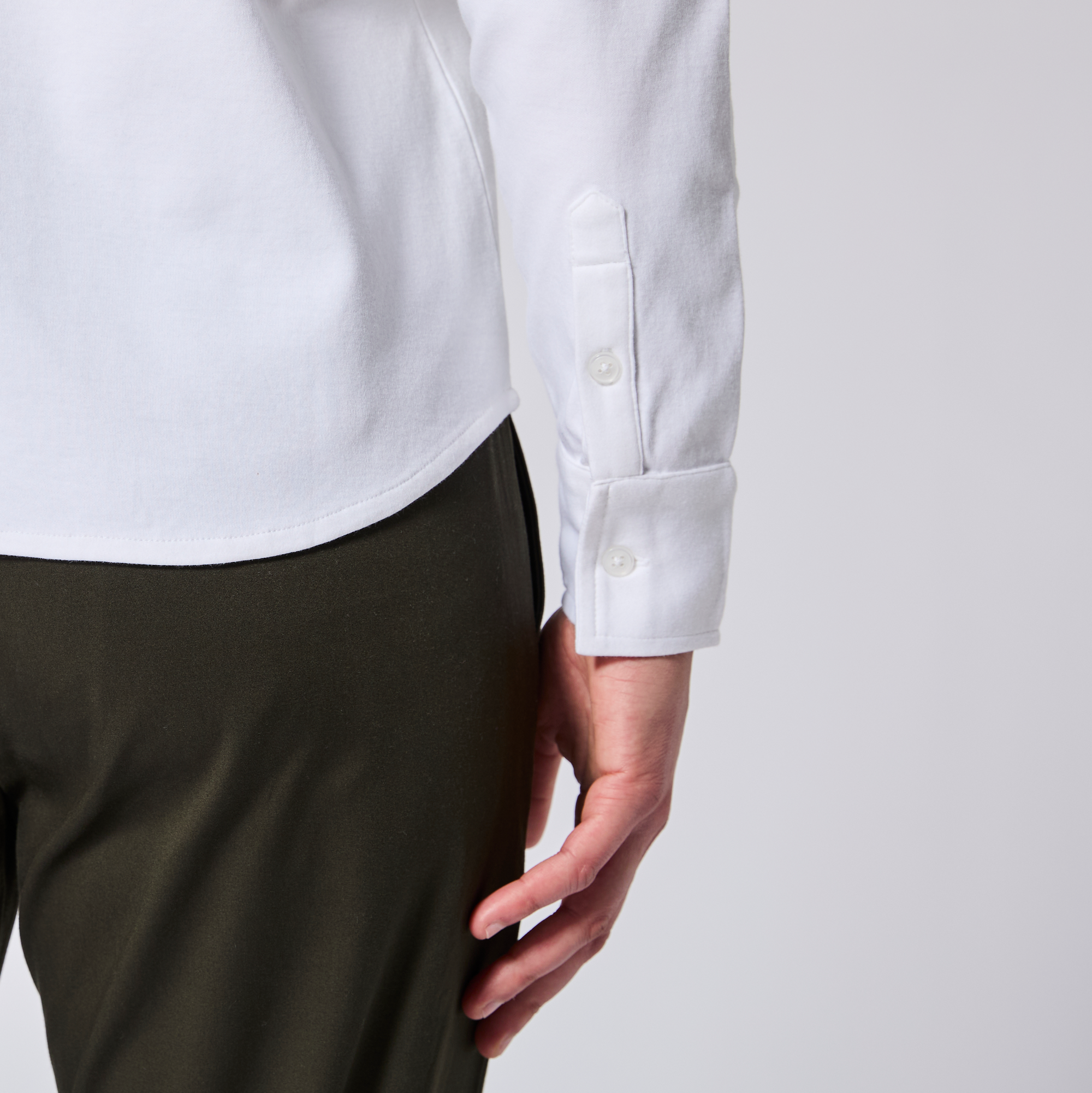 Close up of hem and cuff of the white double jersey shirt made for women, trans, masc and non-binary folk. Color: White