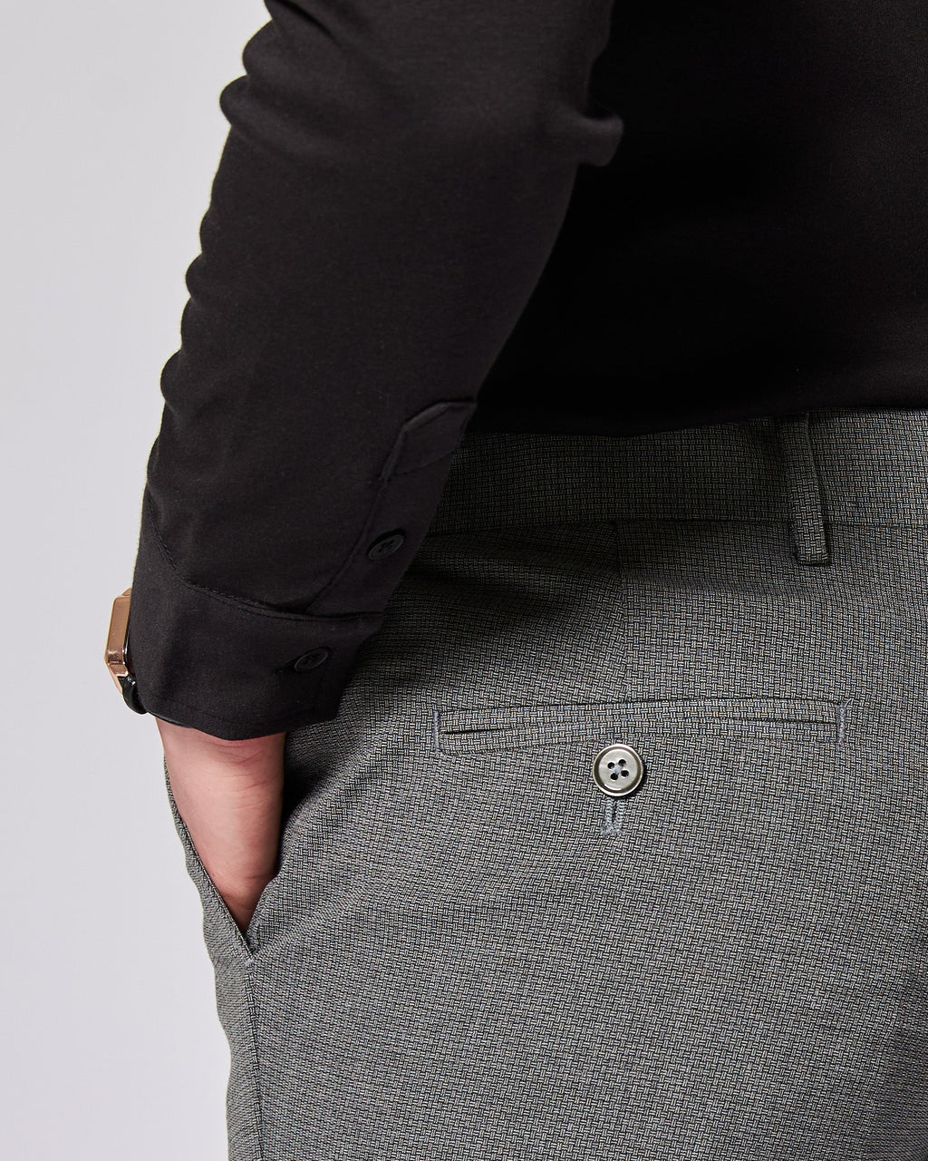 Gray pants with a button detail on a plain background. Color: Gray Lattice