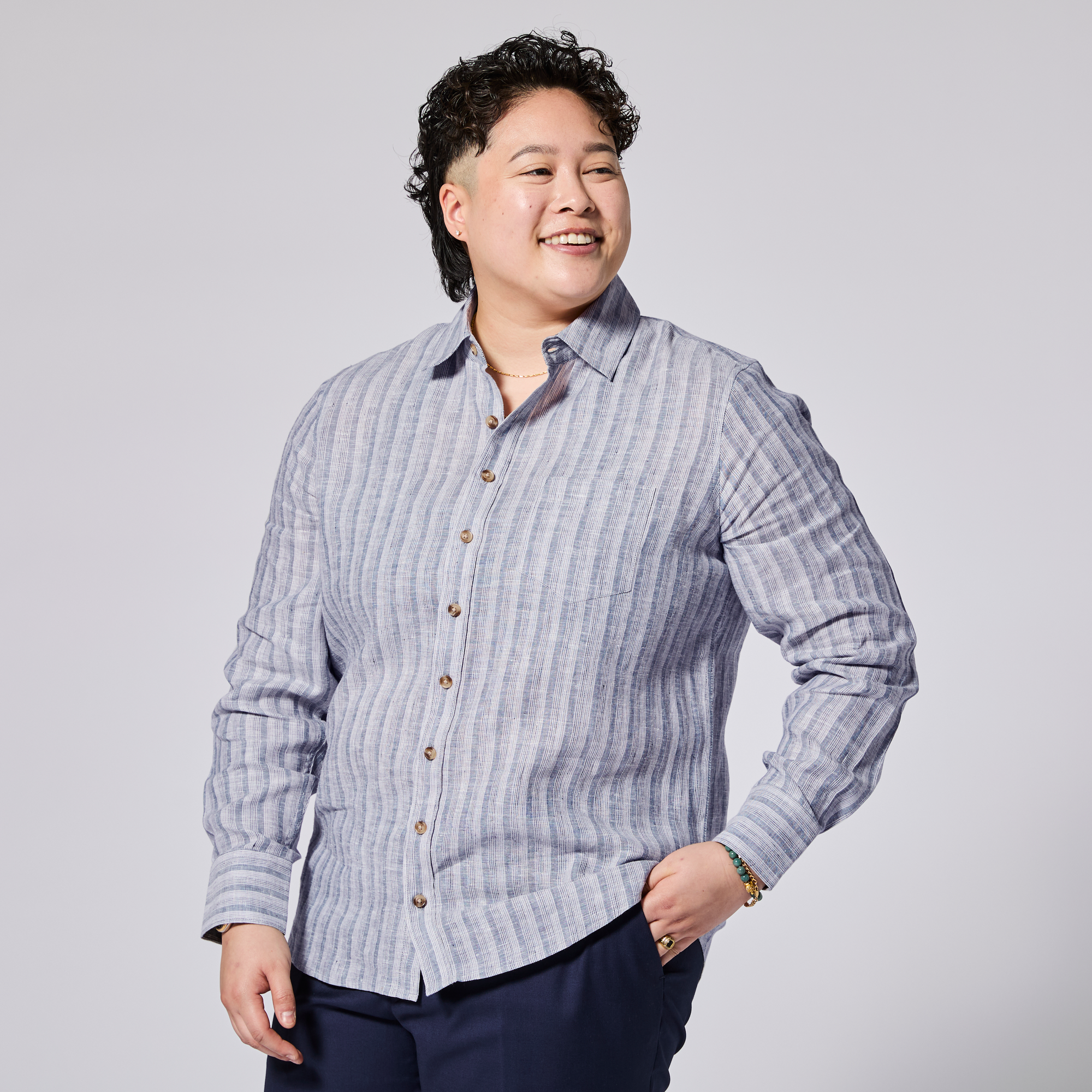 Person wearing a blue striped shirt against a plain background. Color: Coastal Blue