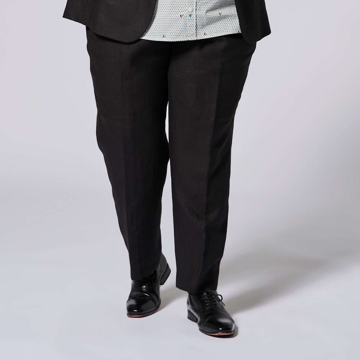 Black suit pants worn by a person on a white background. Color: Black