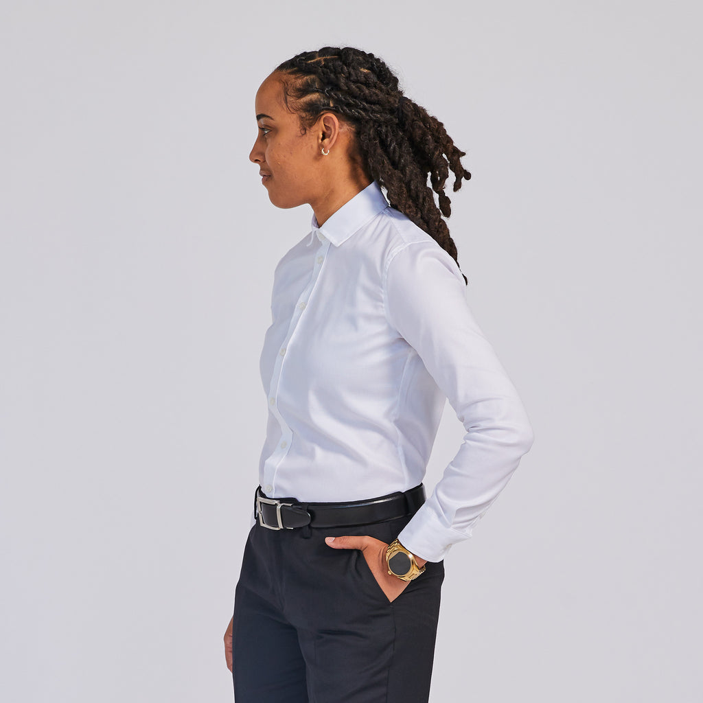 Model standing facing away from the camera with hand in pocket wearing Addams White Easy Care Dress Shirt and Black dress pants by Kirrin Finch Color: White 
