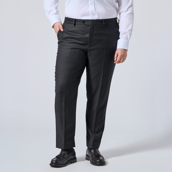 A person wearing dark charcoal gray dress pants with a white button-down shirt and black leather shoes, shown from the waist down against a light gray studio background. Color: Nightfall Birdseye