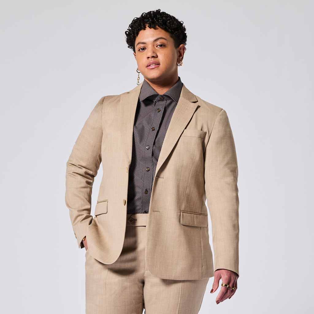 Person wearing a beige suit with a button-up shirt on a white background. Color: Desert