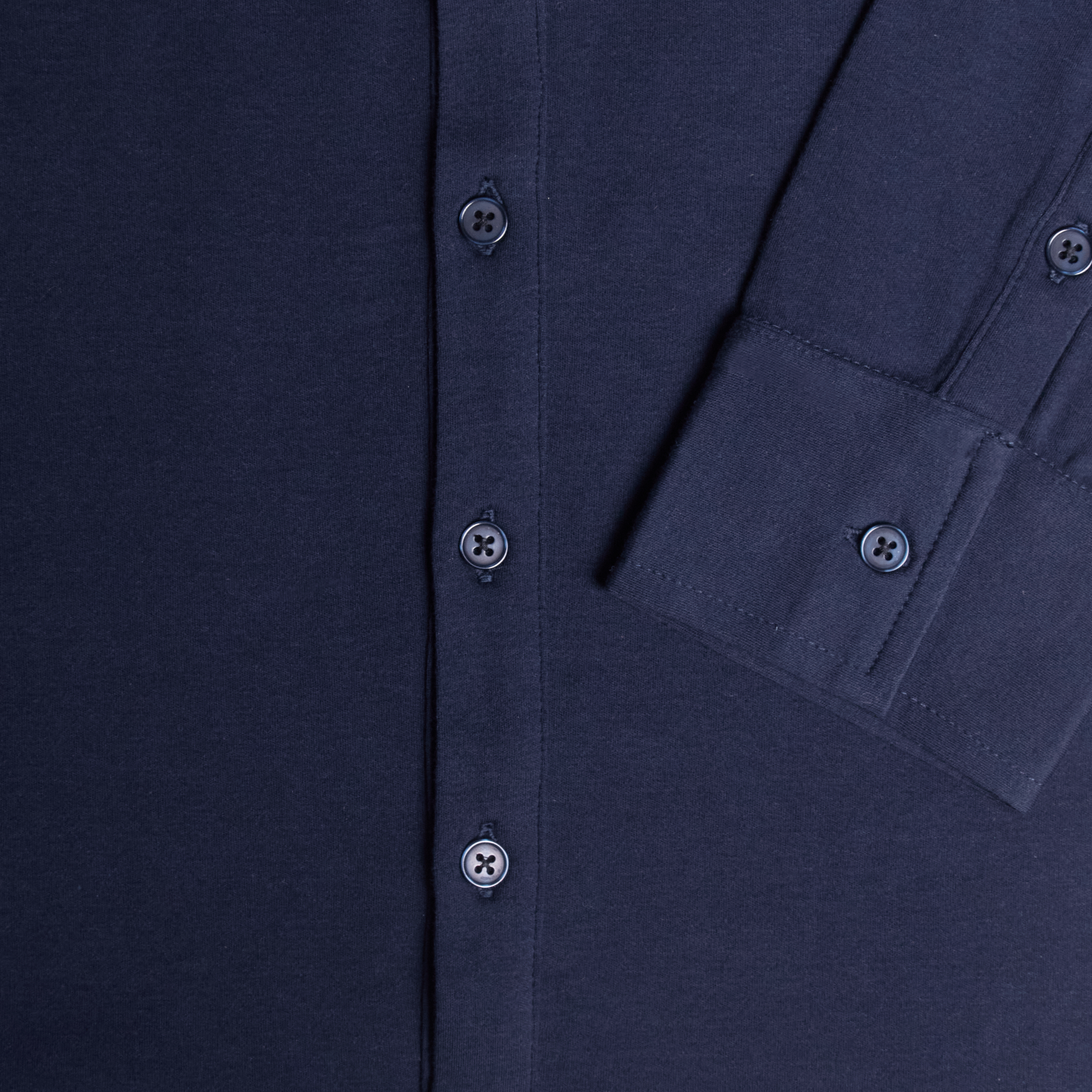 Close-up of a black shirt with button details. Color: Navy