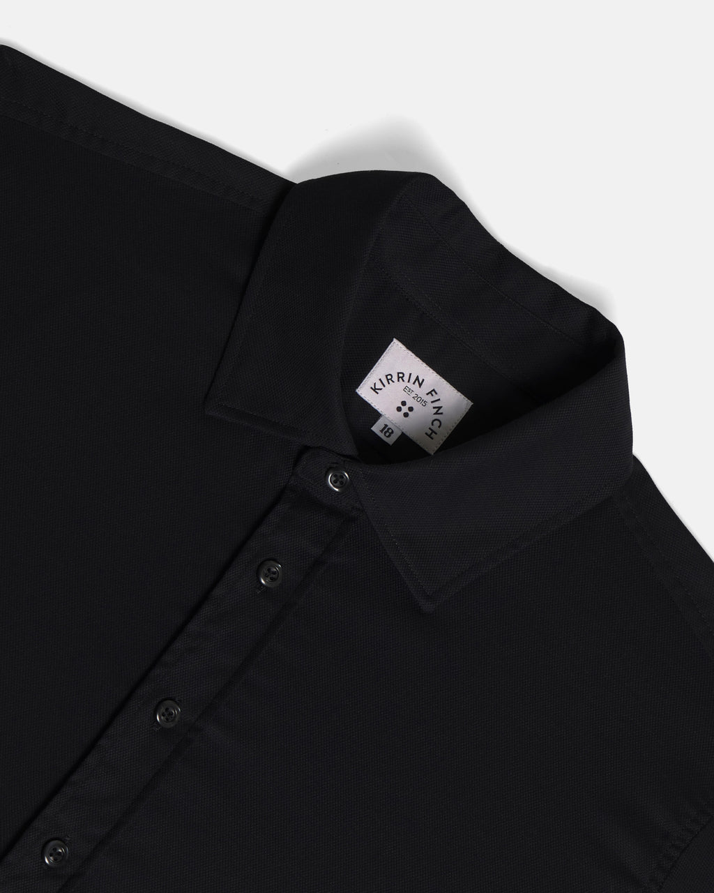 Close-up of a black button-down shirts collar. Color: Black
