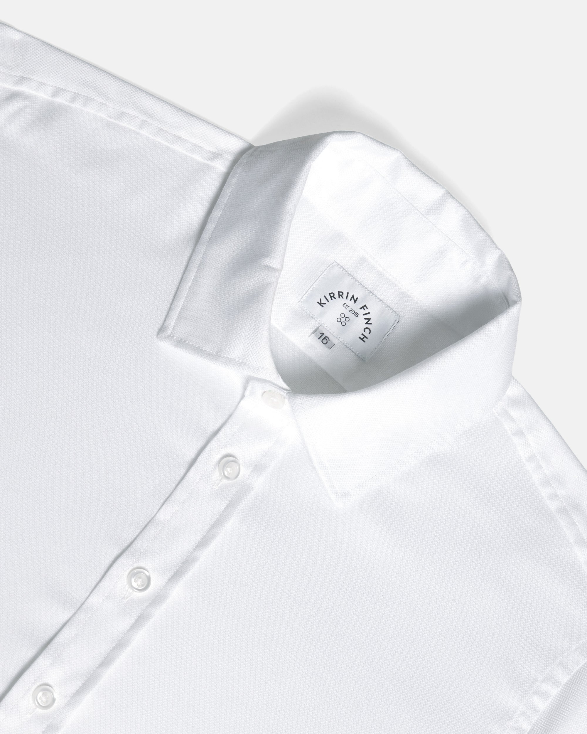 Close-up of a white long-sleeve dress shirt showing the collar, front button placket. Color: White