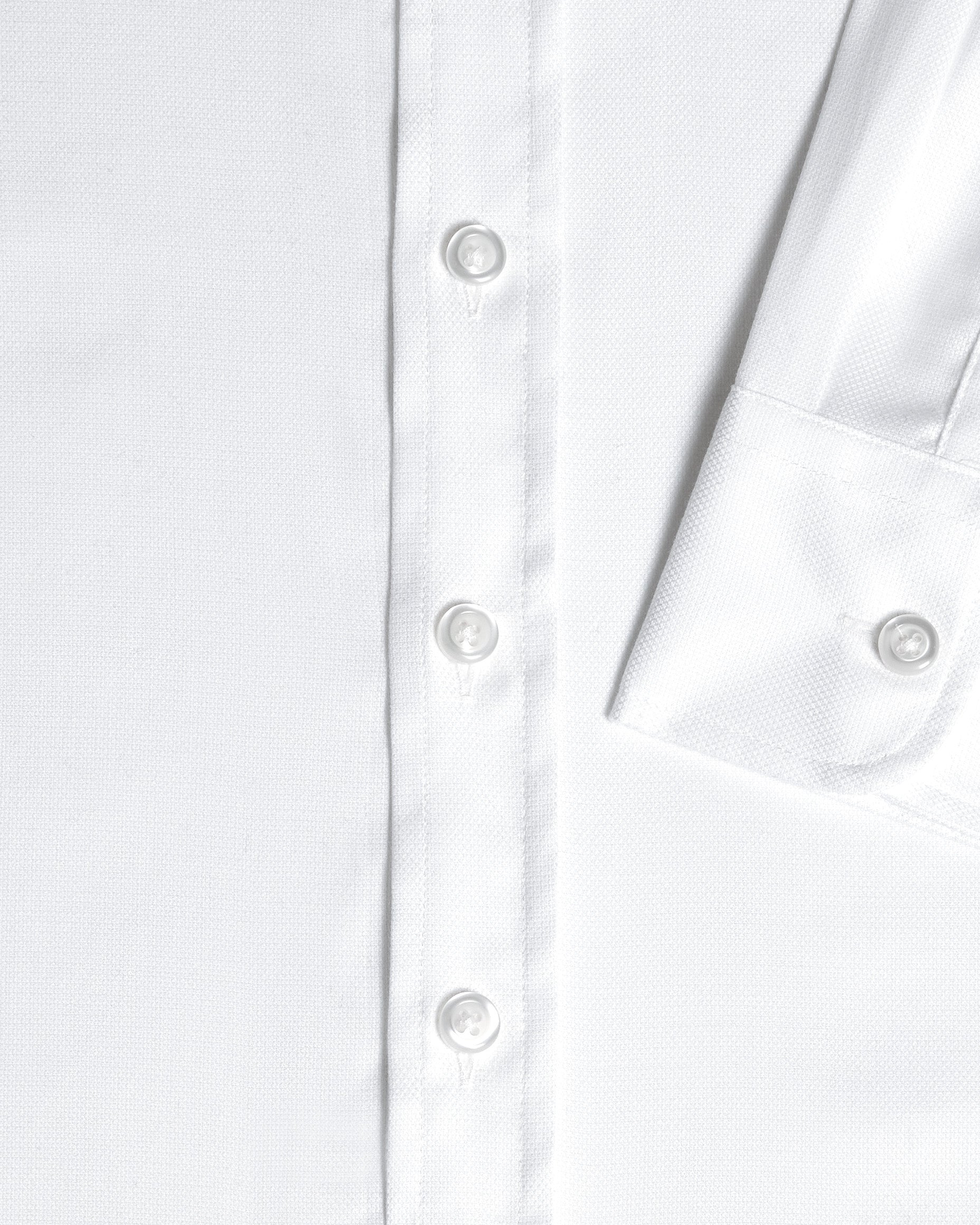 Close-up detail of a white long-sleeve button-down shirt showing the front placket with white buttons and sleeve cuff. Color: White