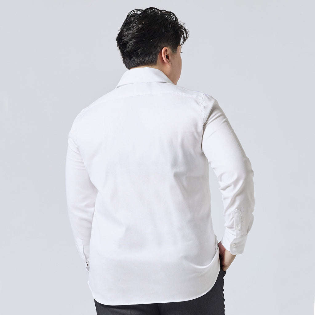Model viewed from behind wearing a white long-sleeve button-down shirt and dark trousers, standing against a light gray studio background. Color: White