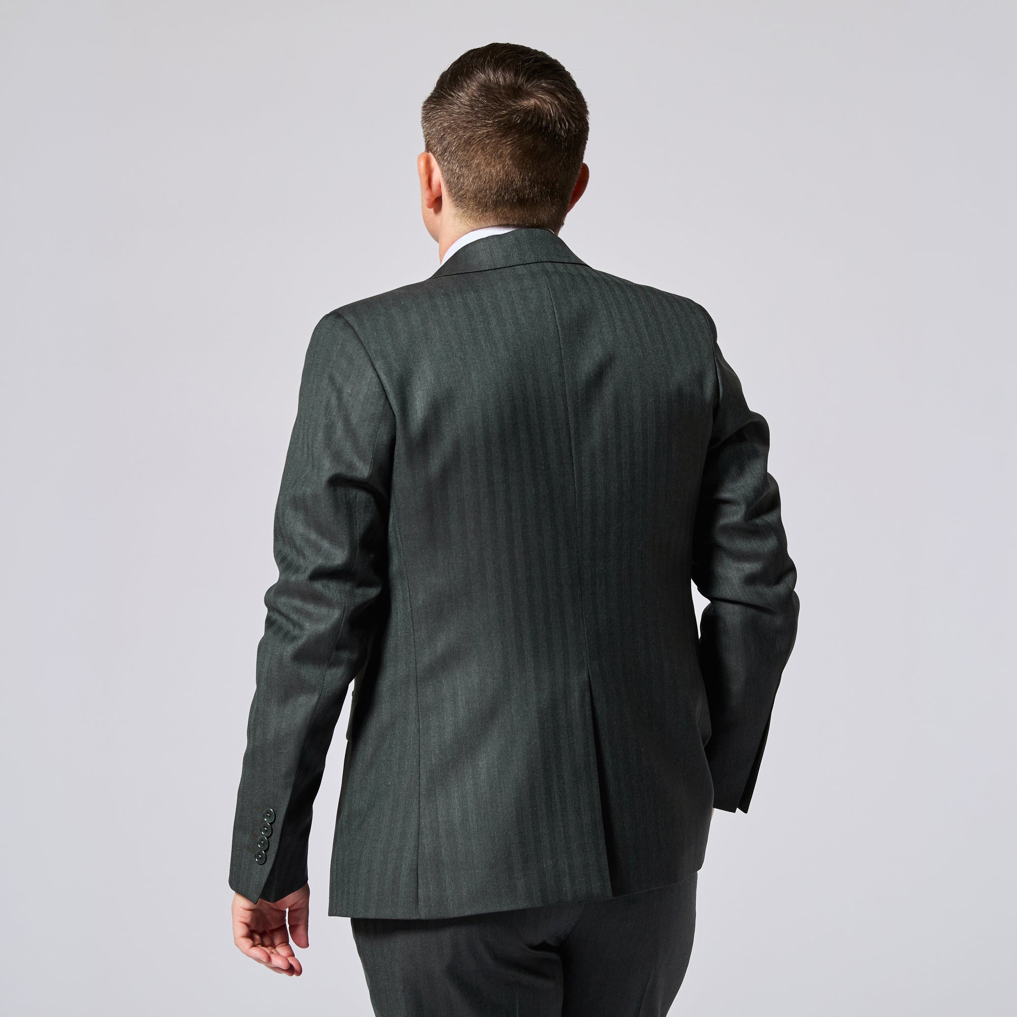 Model photographed from behind wearing a dark green blazer with matching pants. Color: Midnight Pine Herringbone