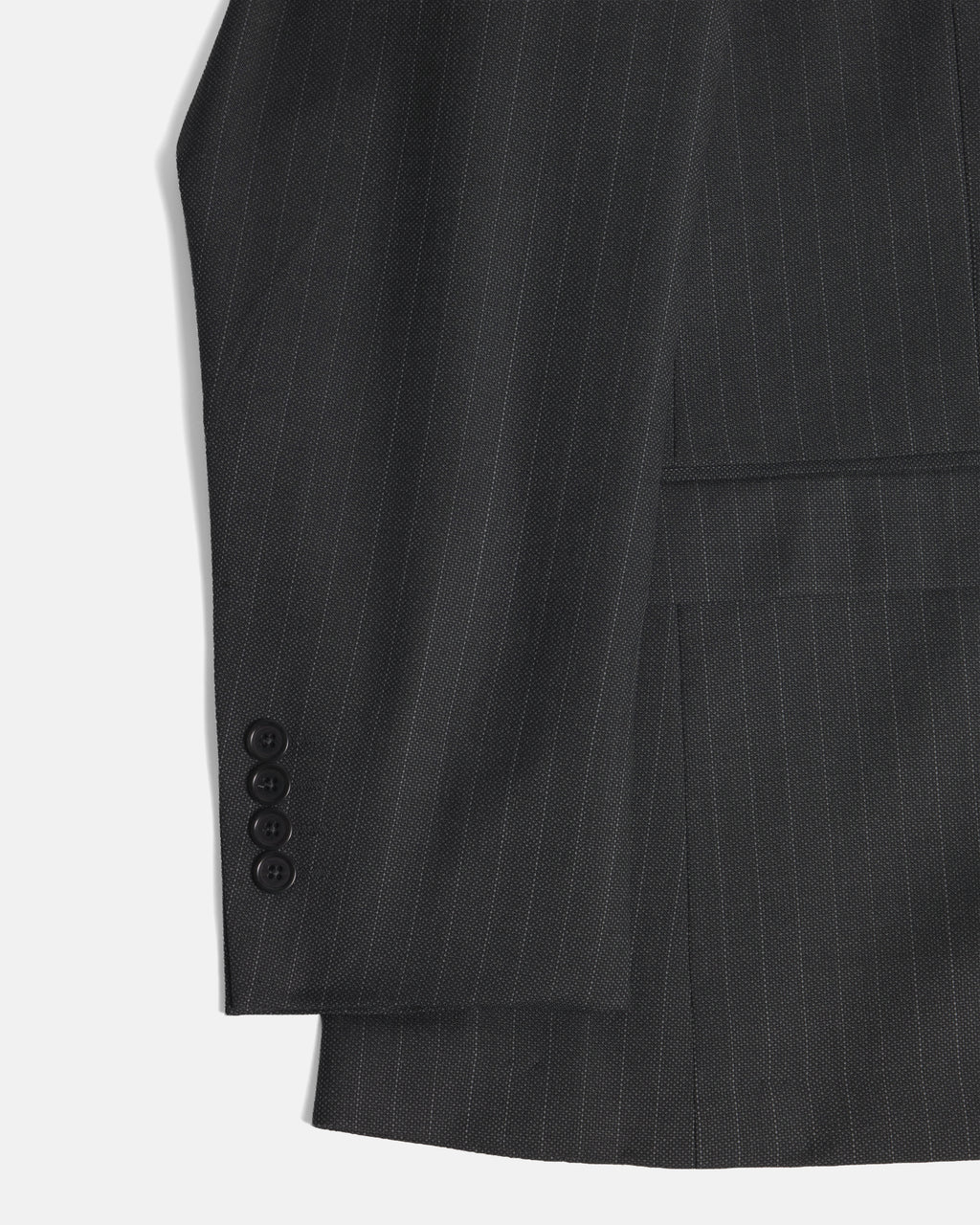 Close-up of a dark charcoal gray pinstripe suit jacket, showing the fabric texture, a buttoned cuff, and a pocket on a light gray background. Color: Shadow Pinstripe