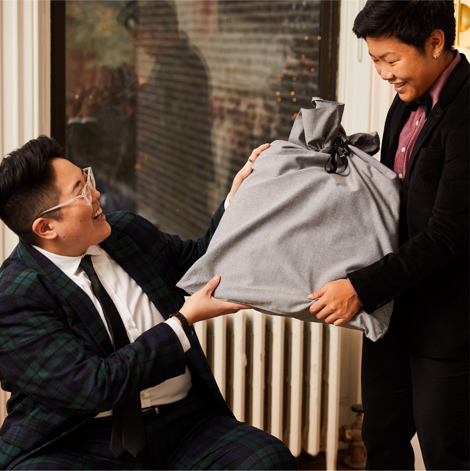 Two suited folks holding the Kirrin Finch Gift Bag