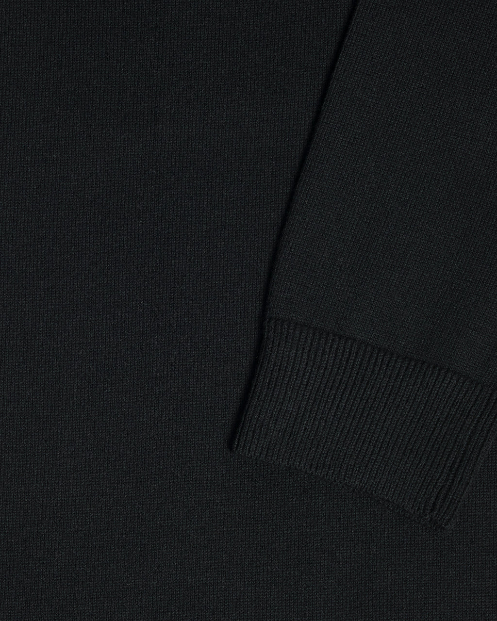 Close-up of a black garment, showing the texture of the fabric and a folded cuff detail. Color: Gray Tipped