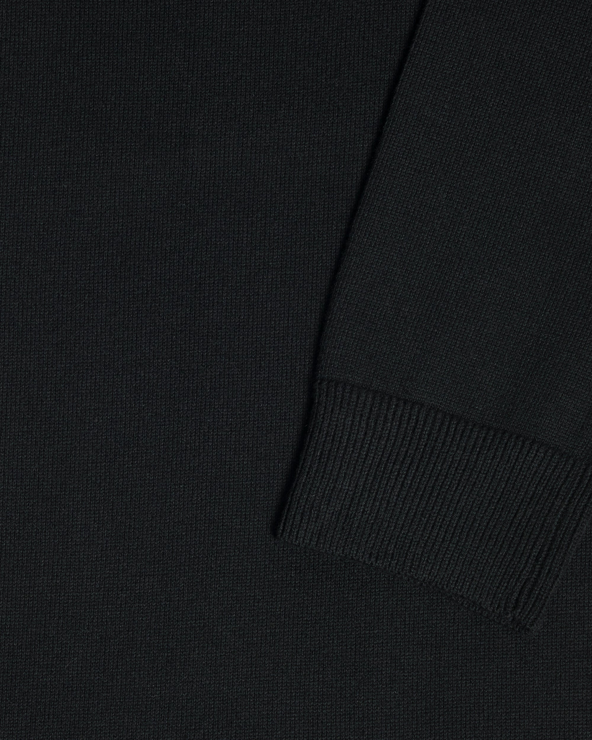 Close-up of a black garment, showing the texture of the fabric and a folded cuff detail. Color: Gray Tipped