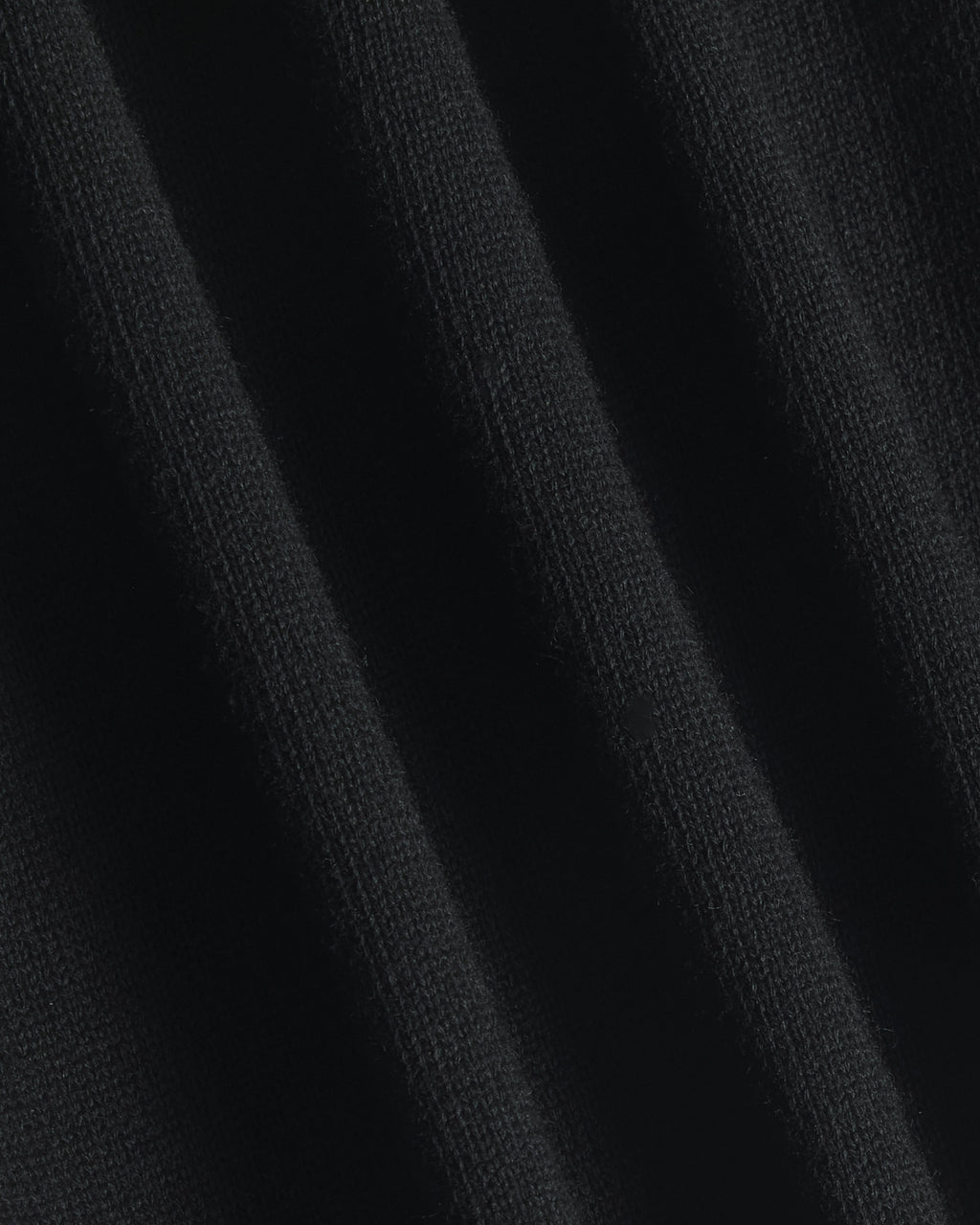 Close-up of a black ribbed knit fabric texture with soft vertical folds. Color: Gray Tipped