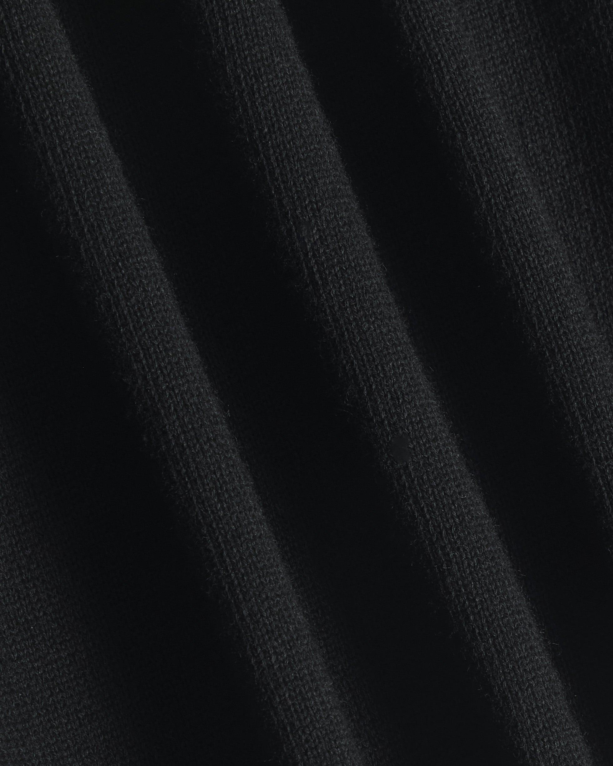 Close-up of a black ribbed knit fabric texture with soft vertical folds. Color: Gray Tipped