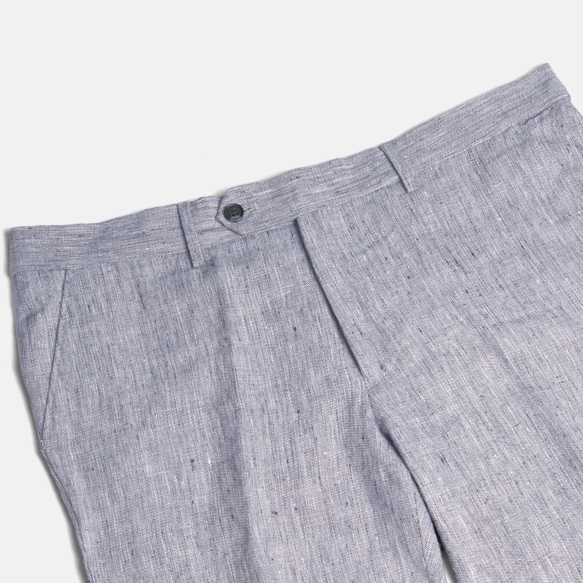 Close-up of gray pleated pants on a white background. Color: Graphite