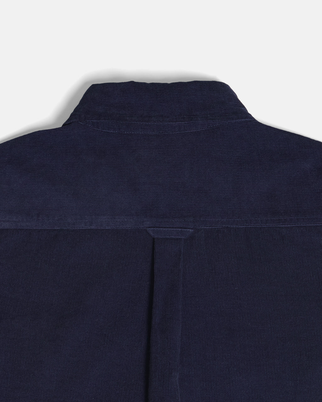 Close-up of the back collar and upper back of a dark navy blue corduroy shirt jacket, showing the textured corduroy fabric and a central seam. Color: Maritime Blue