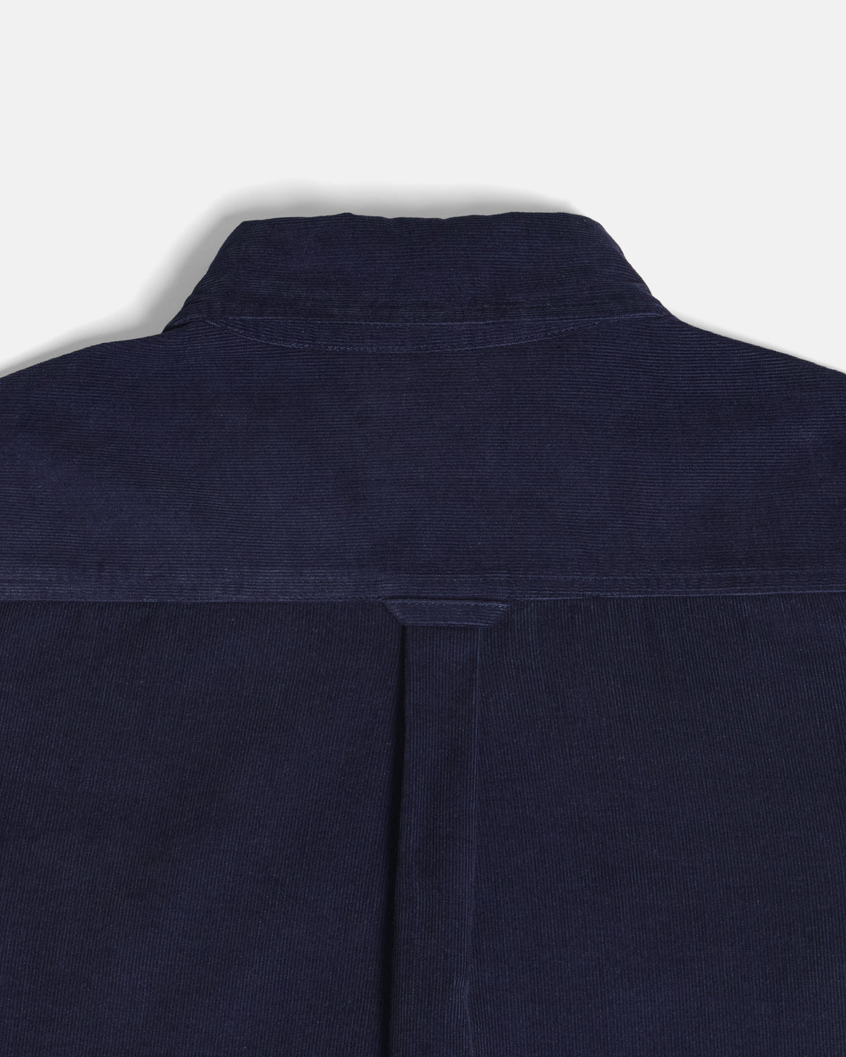 Close-up of the back collar and upper back of a dark navy blue corduroy shirt jacket, showing the textured corduroy fabric and a central seam. Color: Maritime Blue